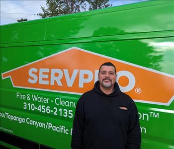 SERVPRO employee in front of green background